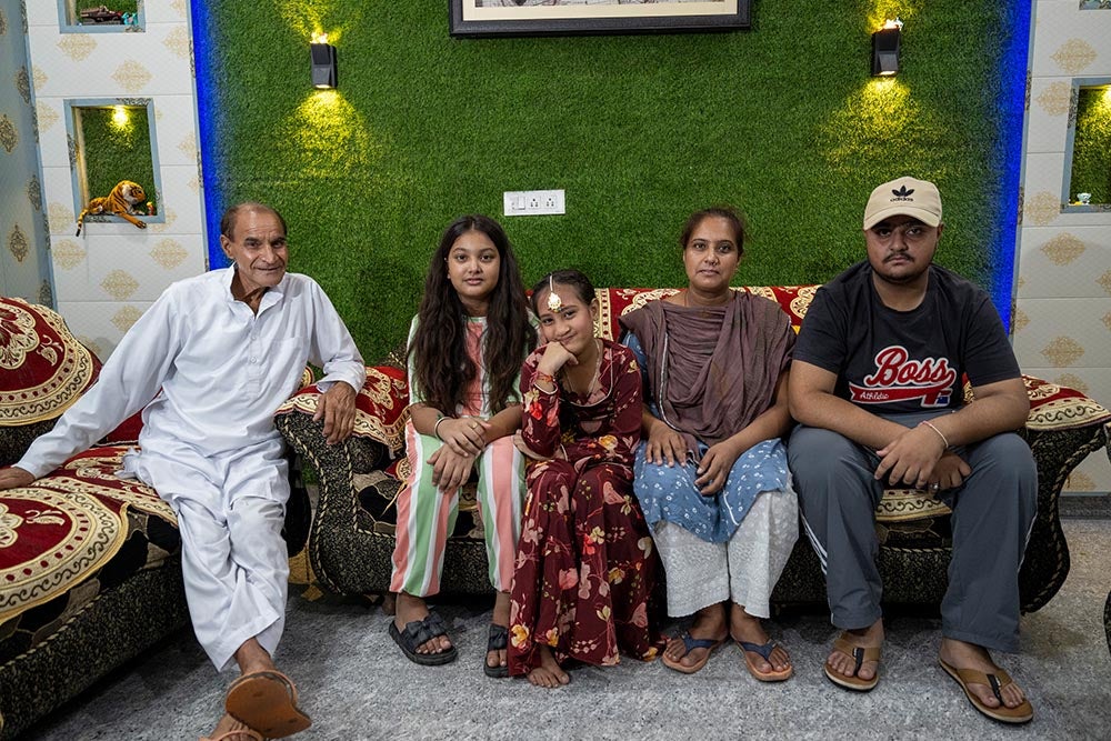 Bhumika souriant avec son grand-père, sa sœur, sa mère Jyoti et son frère, assis après sa chirurgie de la fente