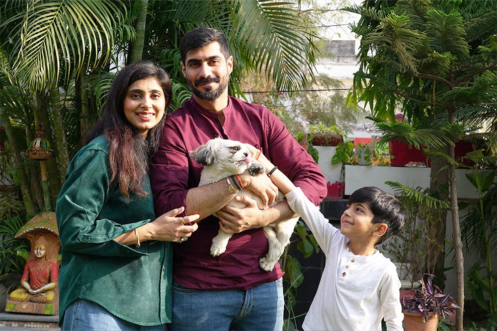 Payal in a park with her husband, son, and dog