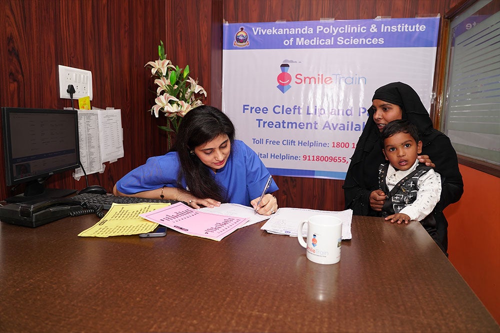 Payal in her office with a patient and his mother