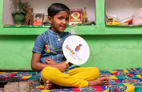 Saraswati tient un éventail du Smile Train