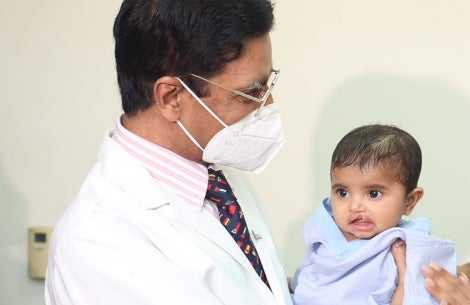 Doctor holding a baby born with a cleft