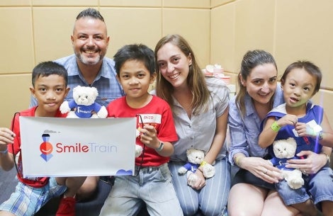 group of smile train supporters poses with patients in Asia