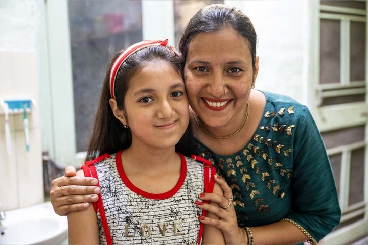 Angel et sa mère, Aarti, sourient devant la caméra